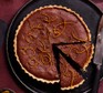 Chocolate orange brownie tart with two slices cut out