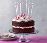 Chocolate & raspberry birthday layer cake served on a cake stand