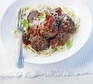 Spaghetti & meatballs sprinkled with grated parmesan in a dish