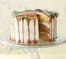 A salted caramel pear cake with rosemary on a cake stand